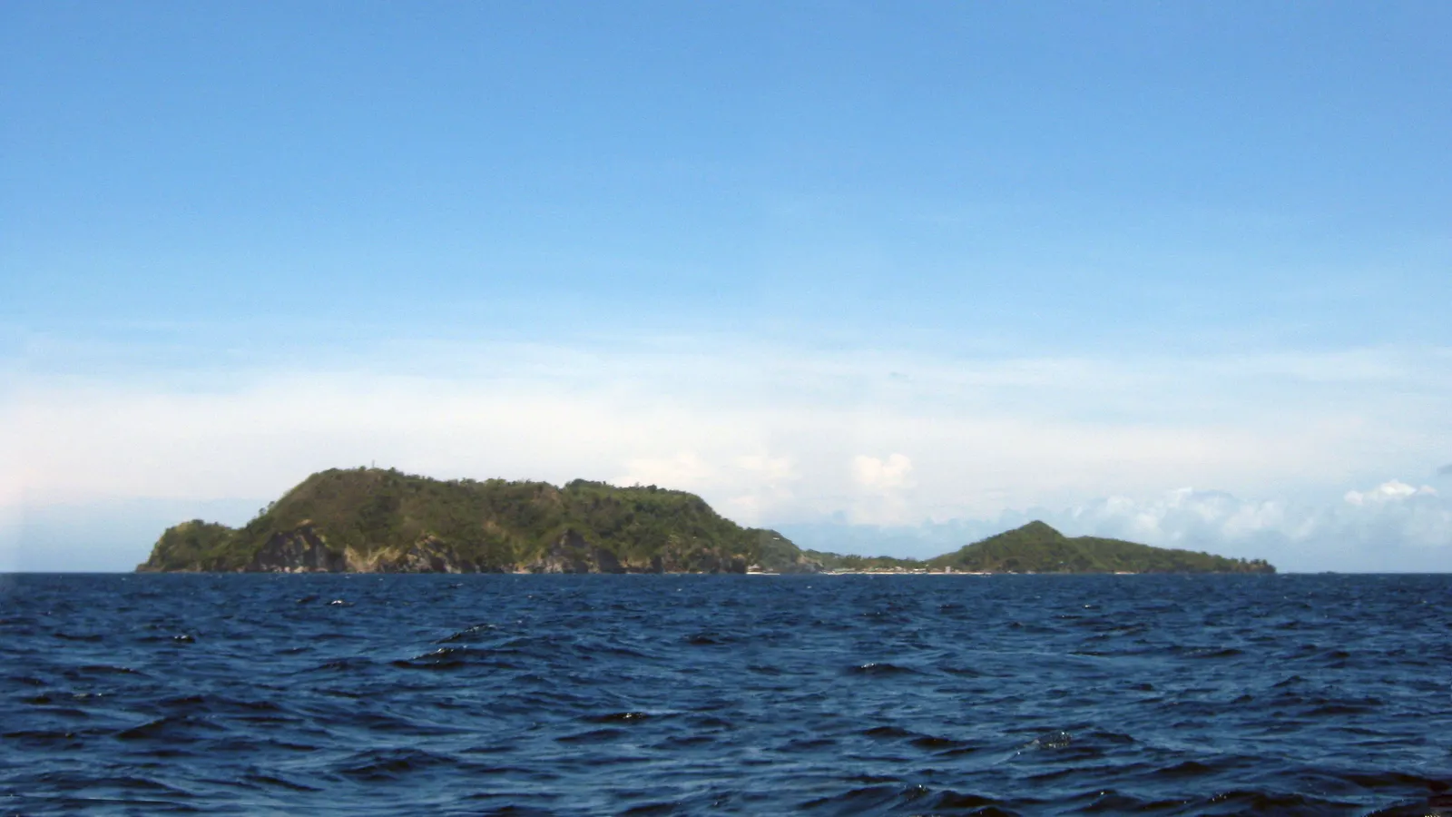 Apo Island seen from the sea, a green volcanic island off the coast of Negros Oriental