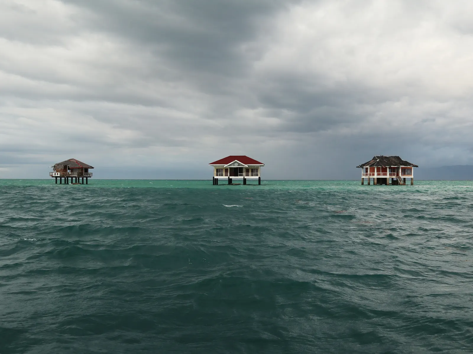 Stilt cottages standing over the water at the Manjuyod white sandbar near Bais, Negros Oriental