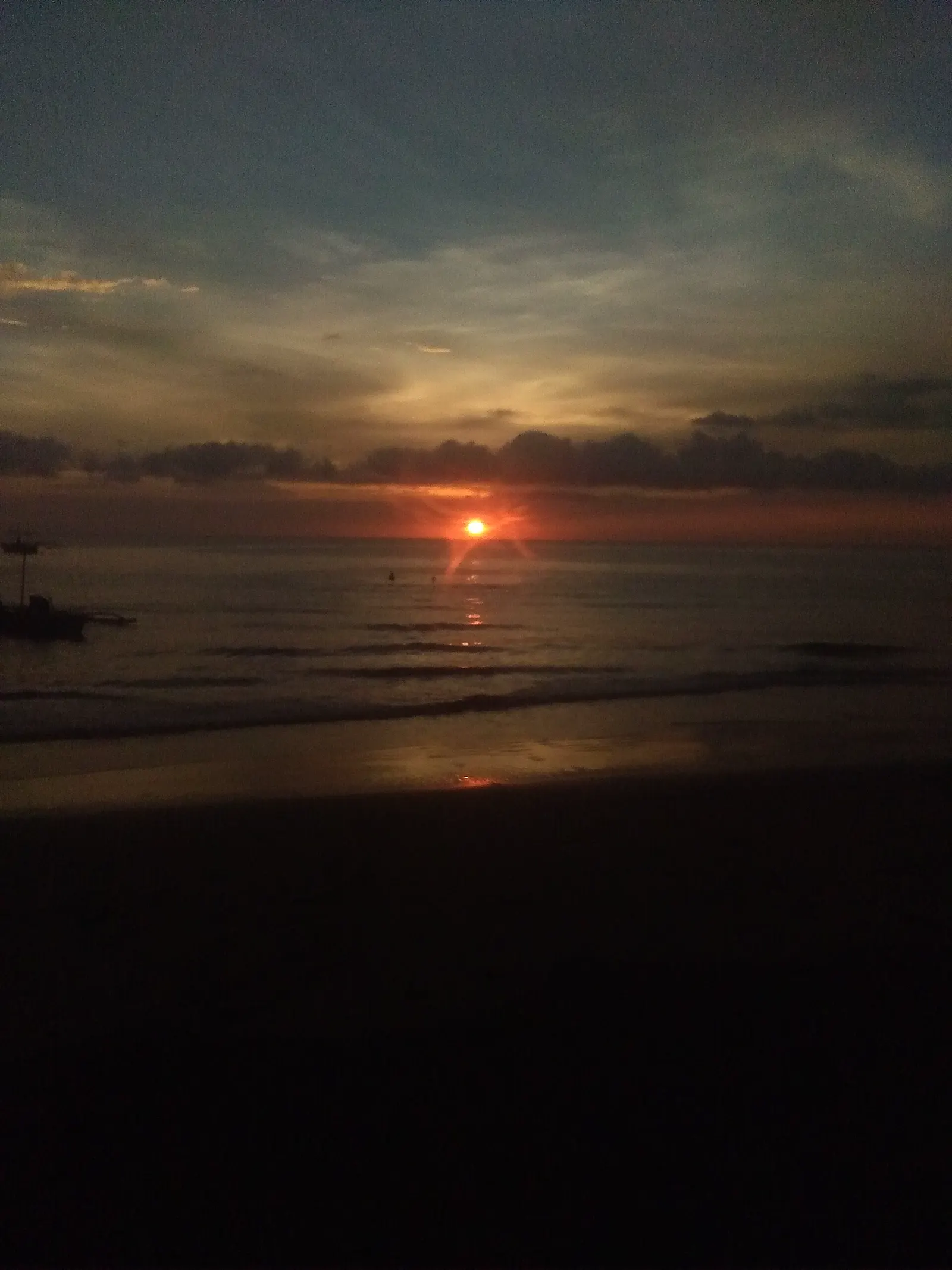 Sunset over the clear water and reef-fringed coast of south-west Negros Occidental, near Sipalay and Danjugan